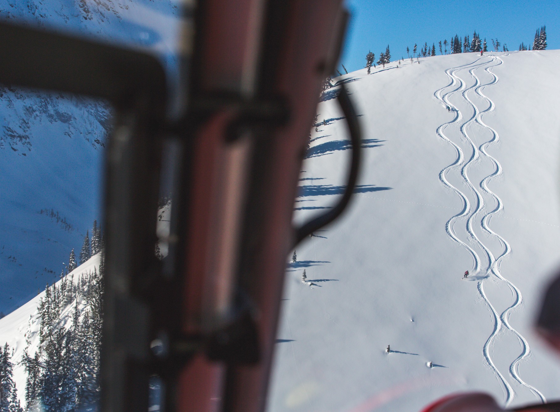 Small group at Stellar Heliskiing ski untracked powder filled alpine bowl