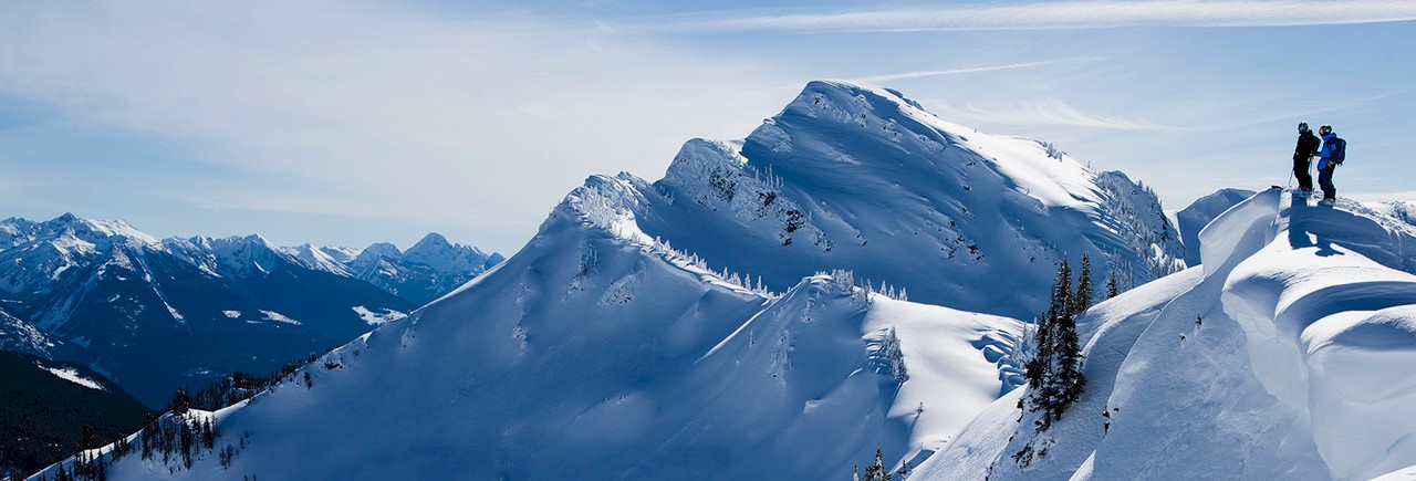 Guest skiing powder ridge line at Stellar Heliskiing, Kaslo, BC.